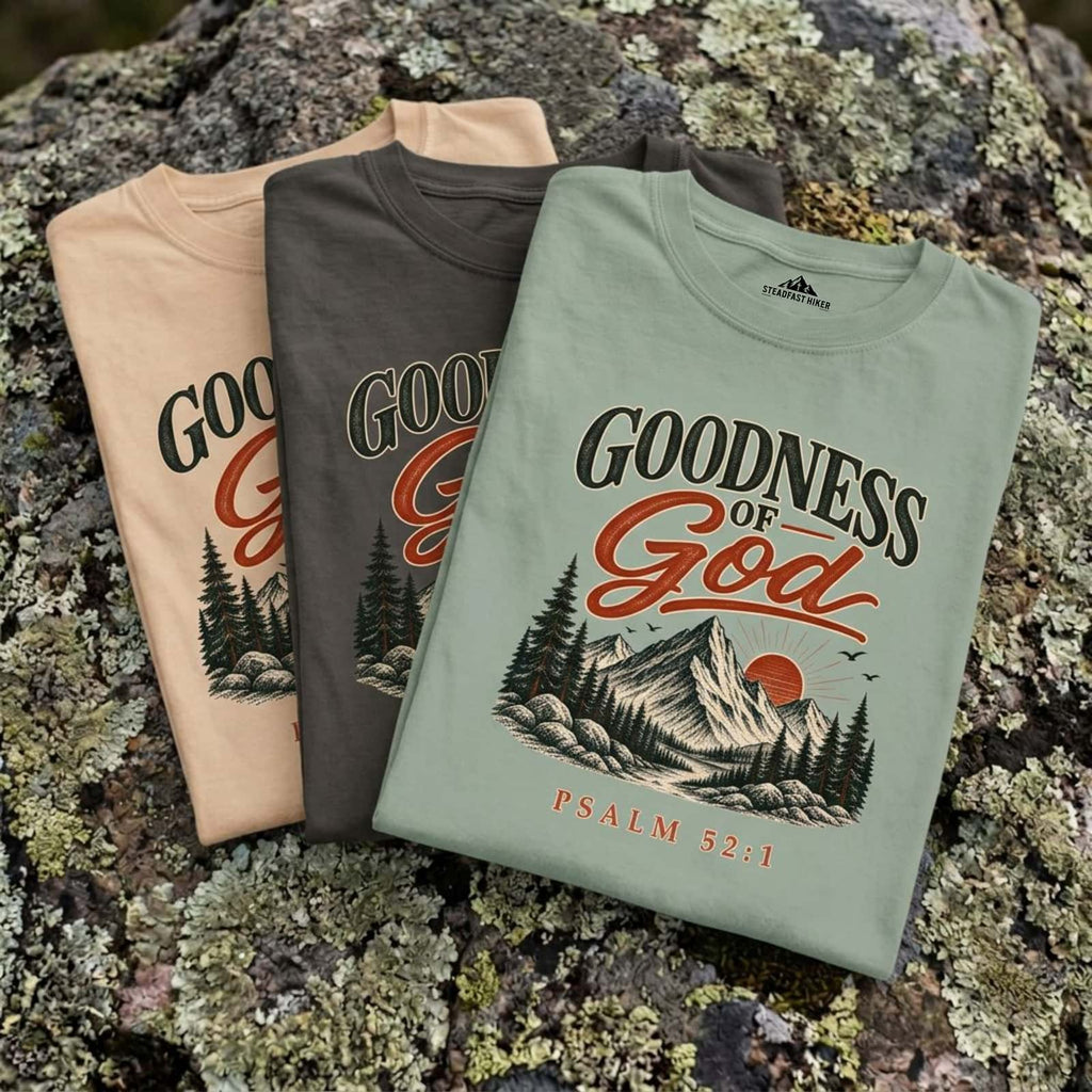 Goodness of God Psalm 52:1 t-shirt folded in Ivory, Pepper and Bay on a mossy granite boulder