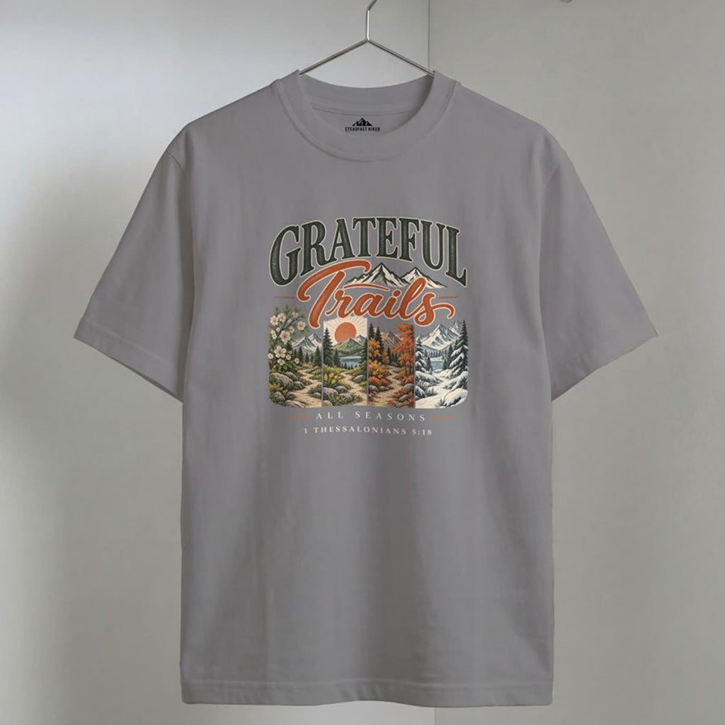 Grey Grateful Trails Christian hiking t-shirt on a wooden hanger, 1 Thessalonians 5:18