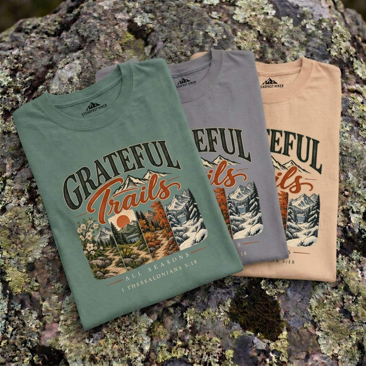 Grateful Trails Christian hiking t-shirts in Ivory, Gray and Light Green laid on a rock
