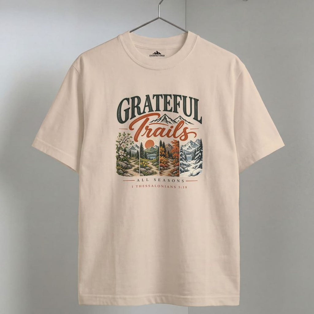 Ivory Grateful Trails Christian hiking t-shirt on a wooden hanger, 1 Thessalonians 5:18