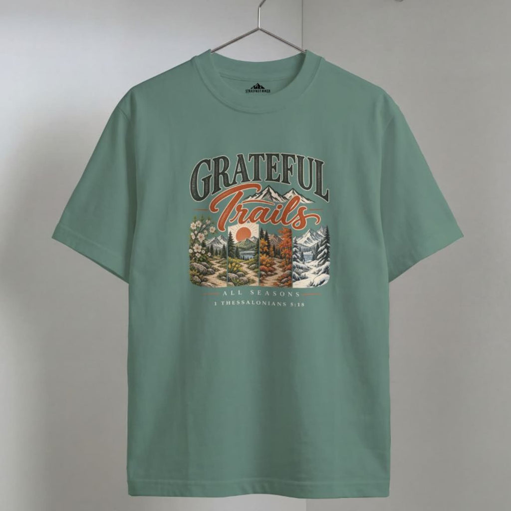 Light Green Grateful Trails Christian hiking t-shirt on a wooden hanger