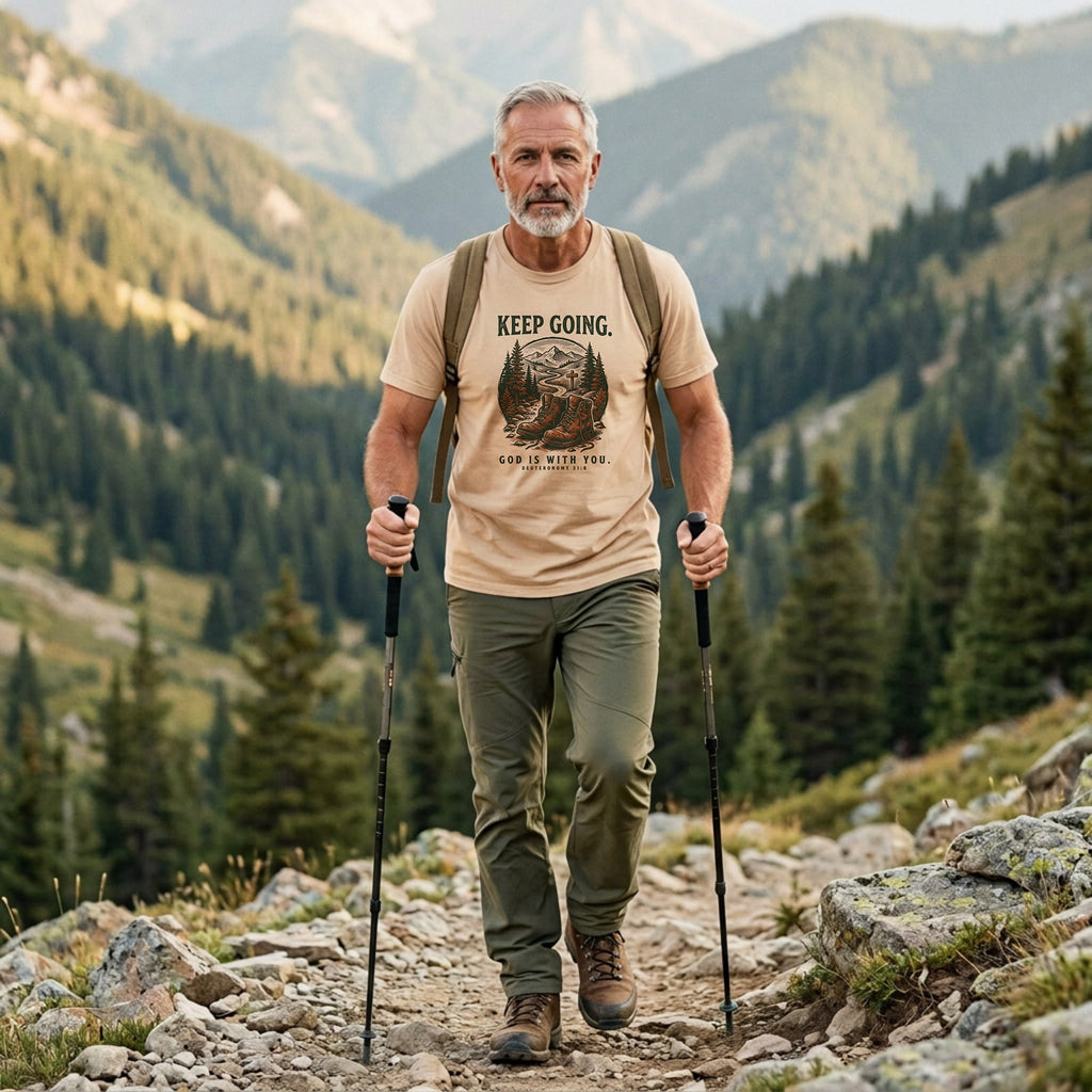Man hiking in an Ivory Keep Going Christian t-shirt on a mountain trail