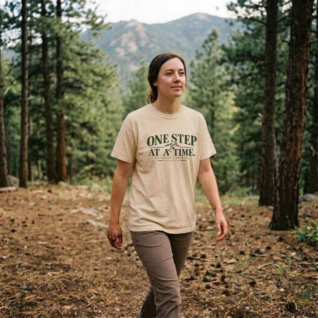 Woman wearing an Ivory One Step at a Time Christian hiking t-shirt outdoors, Psalm 37:23