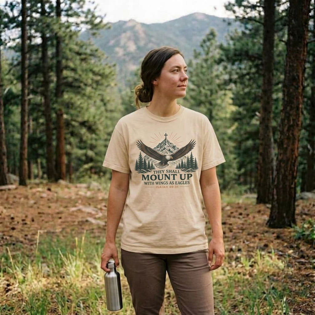 Woman wearing an Ivory They Shall Mount Up Christian hiking t-shirt outdoors, Isaiah 40:31