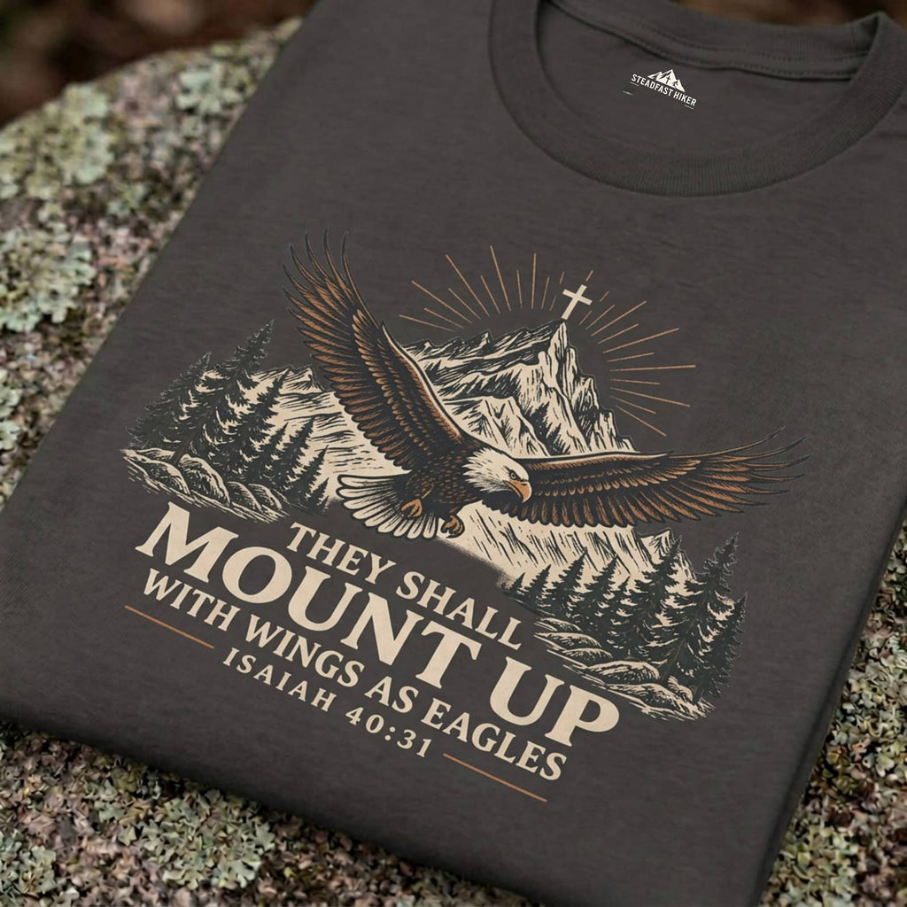 Close-up of the They Shall Mount Up eagle over mountains design printed on a Pepper Christian hiking t-shirt resting on a rock, Isaiah 40:31
