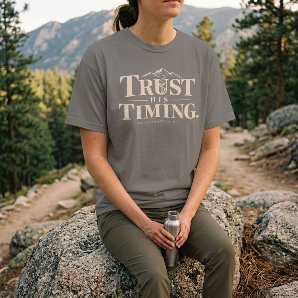 Woman hiking in a Gray Trust His Timing Christian t-shirt on a mountain trail
